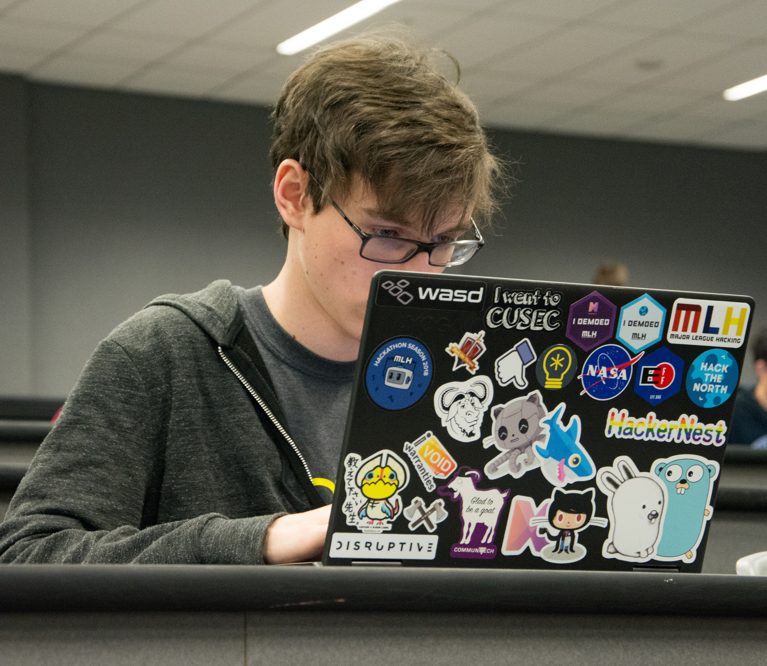me, hacking on a very stickered laptop